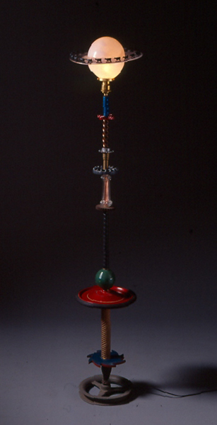 Round and Round is a sculpture lamp that combines hand blown glass and found objects